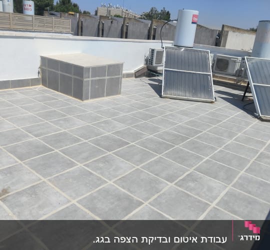גג מרוצף עם לוחות סולאריים ואיטום בין האריחים
